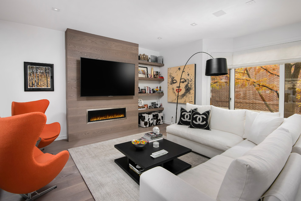 Design ideas for a contemporary open concept family room in Chicago with white walls, a ribbon fireplace, a wood fireplace surround, a wall-mounted tv, dark hardwood floors and brown floor.