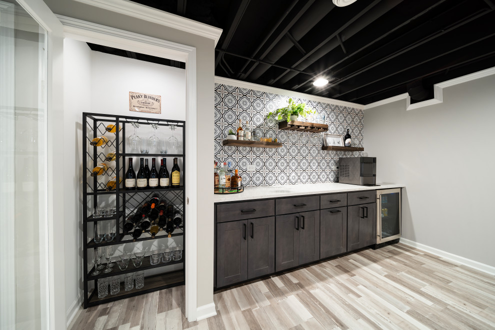 This is an example of a contemporary wet bar in Chicago with shaker cabinets and vinyl floors.