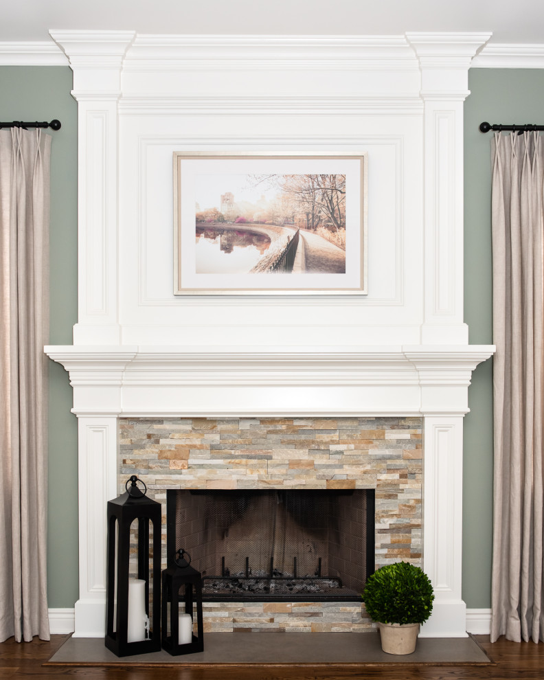Inspiration for a mid-sized traditional enclosed living room in New York with green walls, dark hardwood floors, a standard fireplace, a stone fireplace surround, a wall-mounted tv and brown floor.