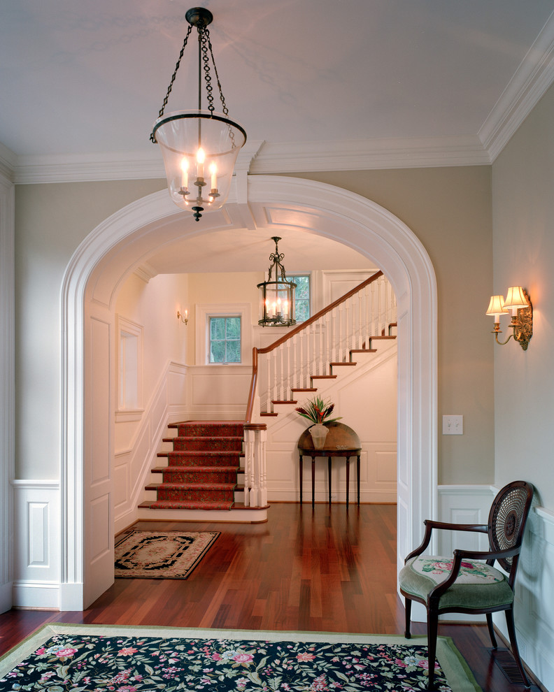 Design ideas for a mid-sized traditional foyer in Other with beige walls, medium hardwood floors, brown floor, a single front door and a dark wood front door.