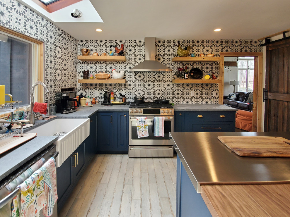 Foto på ett eklektiskt brun kök, med en rustik diskho, luckor med profilerade fronter, blå skåp, bänkskiva i betong, rostfria vitvaror, ljust trägolv, en köksö och beiget golv