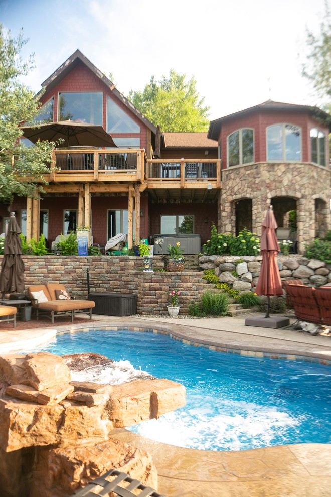 Design ideas for a country backyard kidney-shaped pool in Other with a water feature.