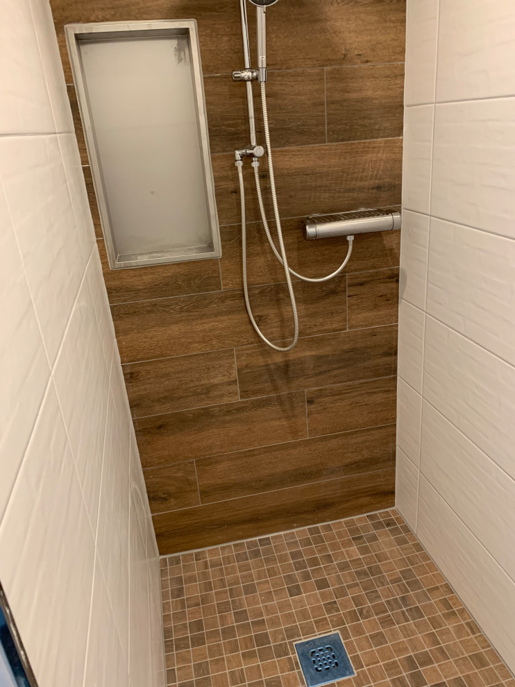 Exempel på ett mellanstort modernt badrum med dusch, med luckor med profilerade fronter, vita skåp, ett platsbyggt badkar, en kantlös dusch, en toalettstol med separat cisternkåpa, vit kakel, keramikplattor, vita väggar, ett integrerad handfat, bänkskiva i akrylsten, brunt golv och med dusch som är öppen