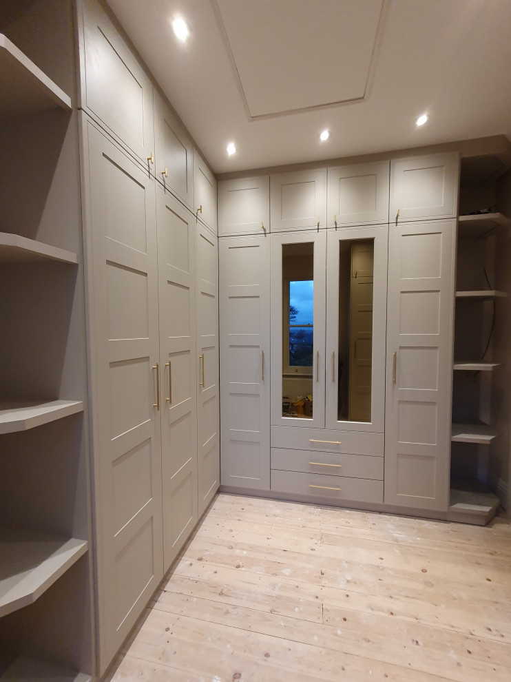 Inspiration for a large traditional storage and wardrobe in Other with shaker cabinets, beige cabinets, medium hardwood floors and yellow floor.