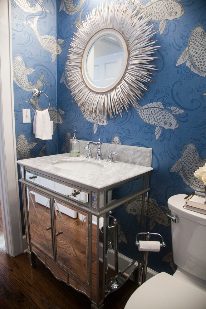 Photo of a small traditional powder room in New Orleans with an undermount sink, a two-piece toilet, dark hardwood floors, furniture-like cabinets and white benchtops.