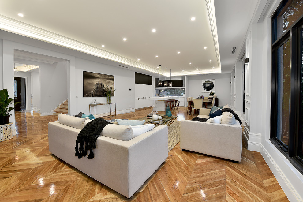 Inspiration for a large traditional enclosed family room in Melbourne with grey walls, light hardwood floors and a wall-mounted tv.