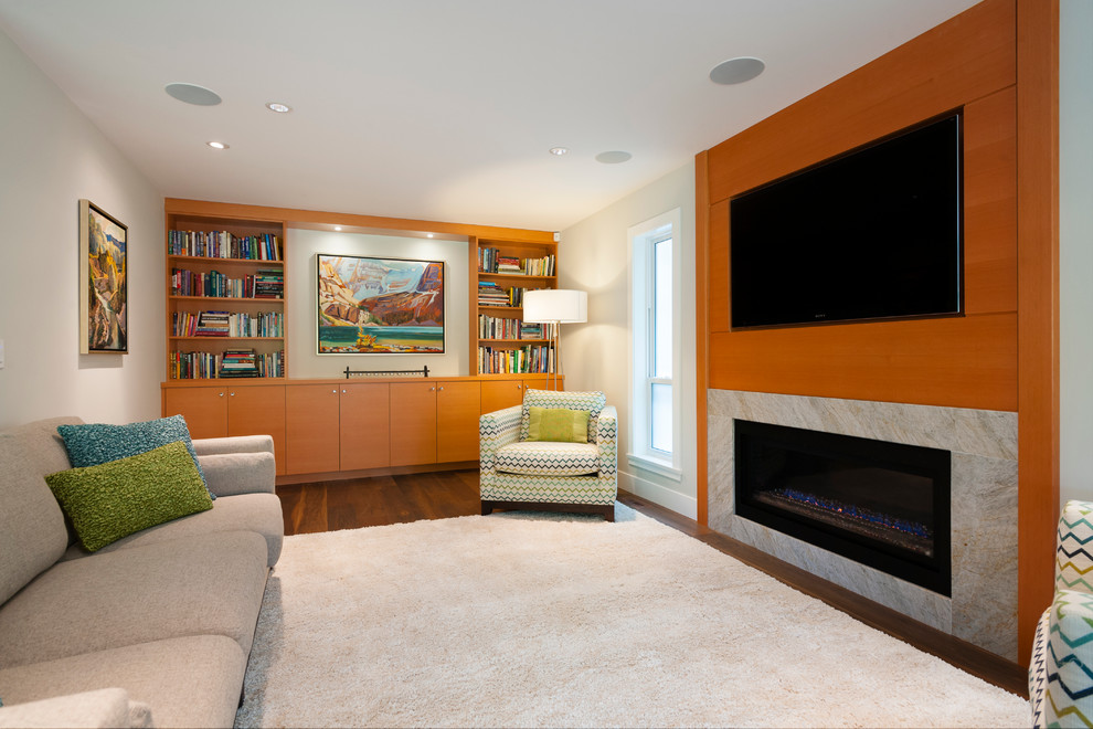 Photo of a large transitional open concept family room in Vancouver with grey walls, medium hardwood floors, a standard fireplace, a stone fireplace surround and a wall-mounted tv.