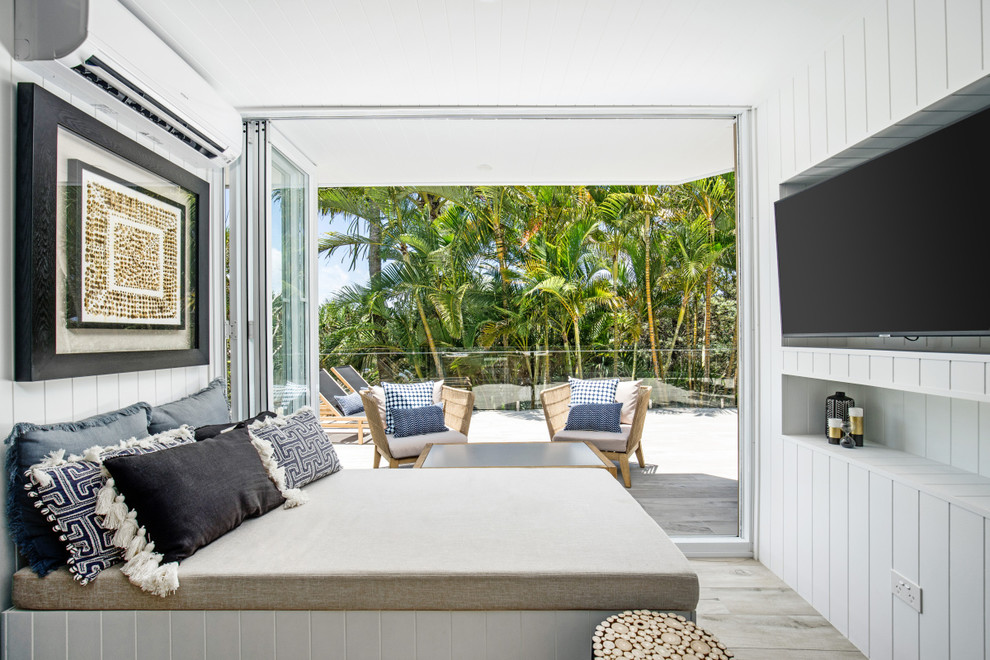 This is an example of a small beach style open concept living room in Sunshine Coast with white walls, porcelain floors, a wall-mounted tv and grey floor.