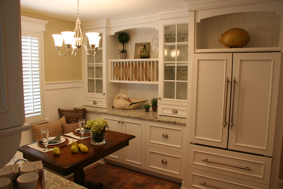 Example of a mid-sized arts and crafts u-shaped brick floor eat-in kitchen design in Chicago with a farmhouse sink, flat-panel cabinets, white cabinets, granite countertops, white backsplash, ceramic backsplash, paneled appliances, yellow walls and an island