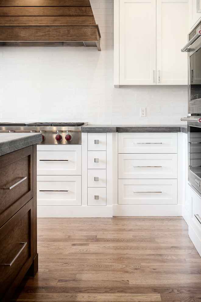 Example of a large transitional u-shaped eat-in kitchen design in Calgary with shaker cabinets, paneled appliances and an island