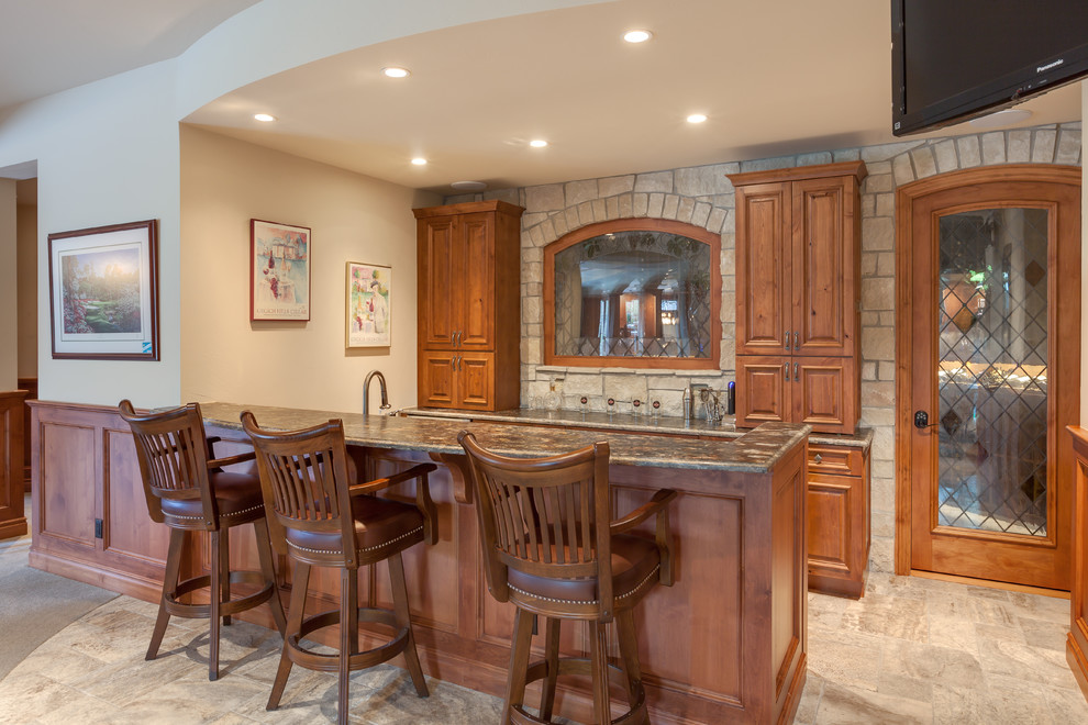 Design ideas for a traditional home bar in Denver with medium wood cabinets, granite benchtops and limestone floors.