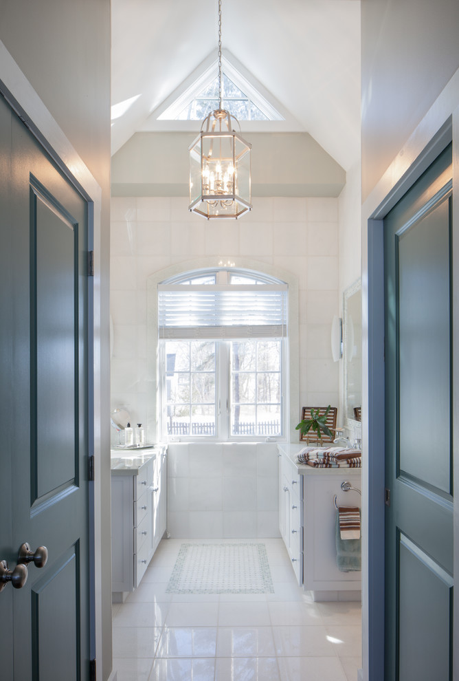 Photo of a large contemporary master bathroom in Portland Maine with white cabinets, white tile, white walls, ceramic floors and an undermount sink.