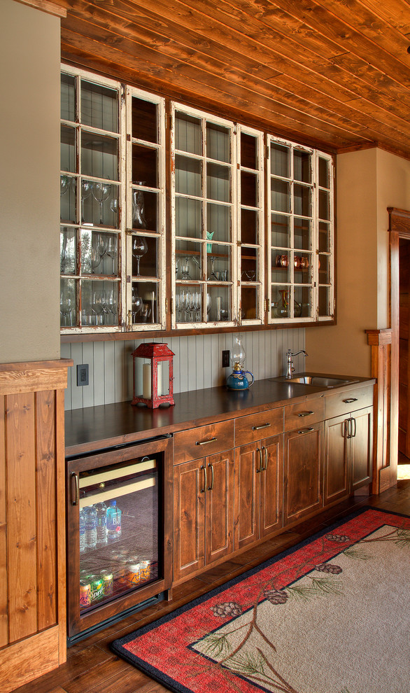Design ideas for a country galley wet bar in Minneapolis with an undermount sink, raised-panel cabinets, medium wood cabinets, wood benchtops, white splashback, timber splashback, medium hardwood floors and brown floor.