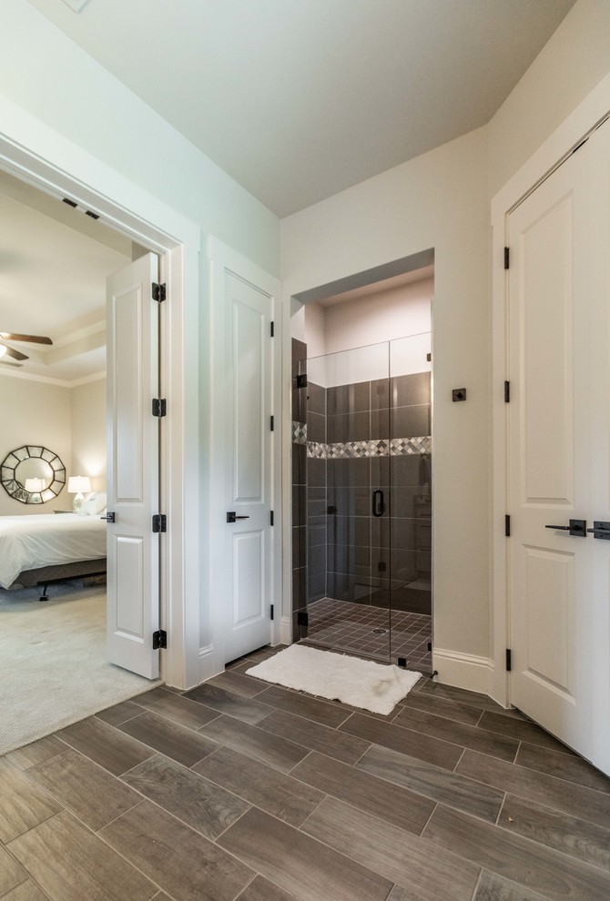 Photo of a large country kids bathroom in Dallas with raised-panel cabinets, an alcove shower, brown tile, ceramic tile, beige walls, ceramic floors, brown floor and a shower curtain.