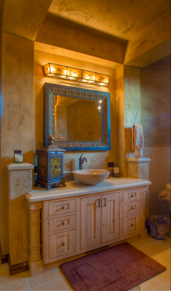 This is an example of a large mediterranean master bathroom in Other with shaker cabinets, light wood cabinets, limestone benchtops, limestone floors, a vessel sink and beige tile.