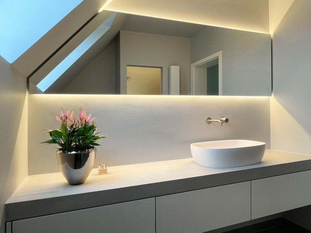 This is an example of a mid-sized contemporary 3/4 wet room bathroom in Dusseldorf with flat-panel cabinets, white cabinets, a wall-mount toilet, gray tile, grey walls, ceramic floors, a vessel sink, grey floor, a hinged shower door, grey benchtops, a single vanity and a freestanding vanity.