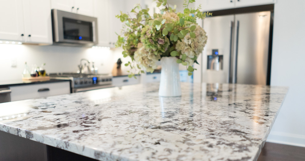 Open concept kitchen - mid-sized transitional l-shaped dark wood floor open concept kitchen idea with an undermount sink, shaker cabinets, white cabinets, granite countertops, gray backsplash, stainless steel appliances and an island