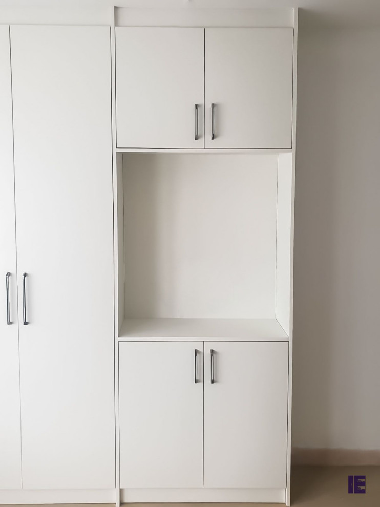 Design ideas for a large modern standard wardrobe in London with flat-panel cabinets and white cabinets.