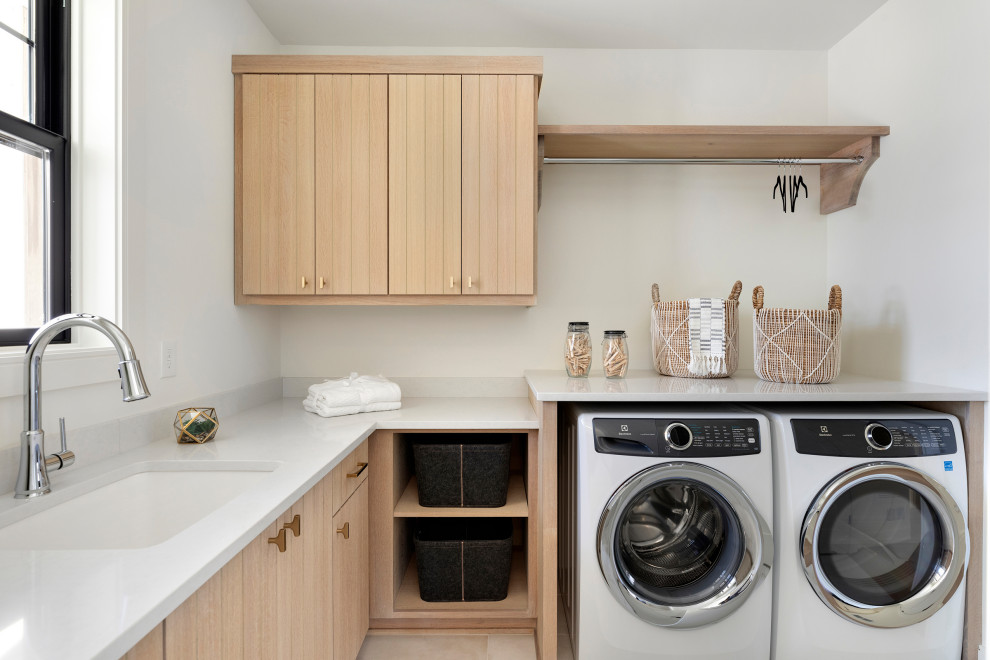 This is an example of a scandinavian laundry room in Minneapolis with light wood cabinets.