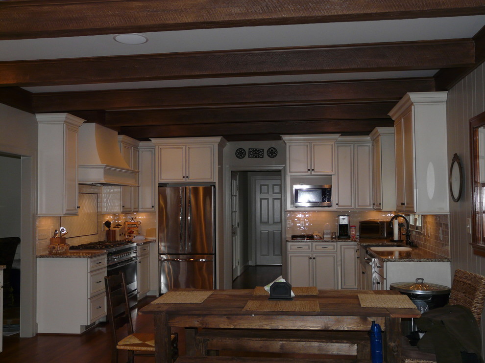 Eat-in kitchen - transitional eat-in kitchen idea in Birmingham with a farmhouse sink, flat-panel cabinets, granite countertops, porcelain backsplash and stainless steel appliances
