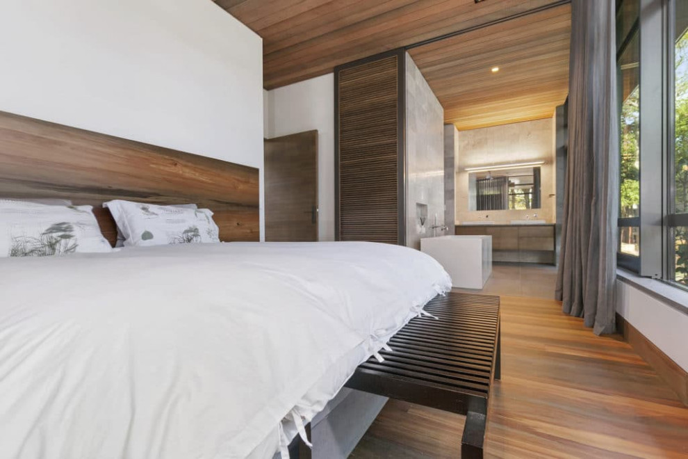 Mid-sized zen medium tone wood floor, brown floor and shiplap ceiling bedroom photo in Auckland with white walls