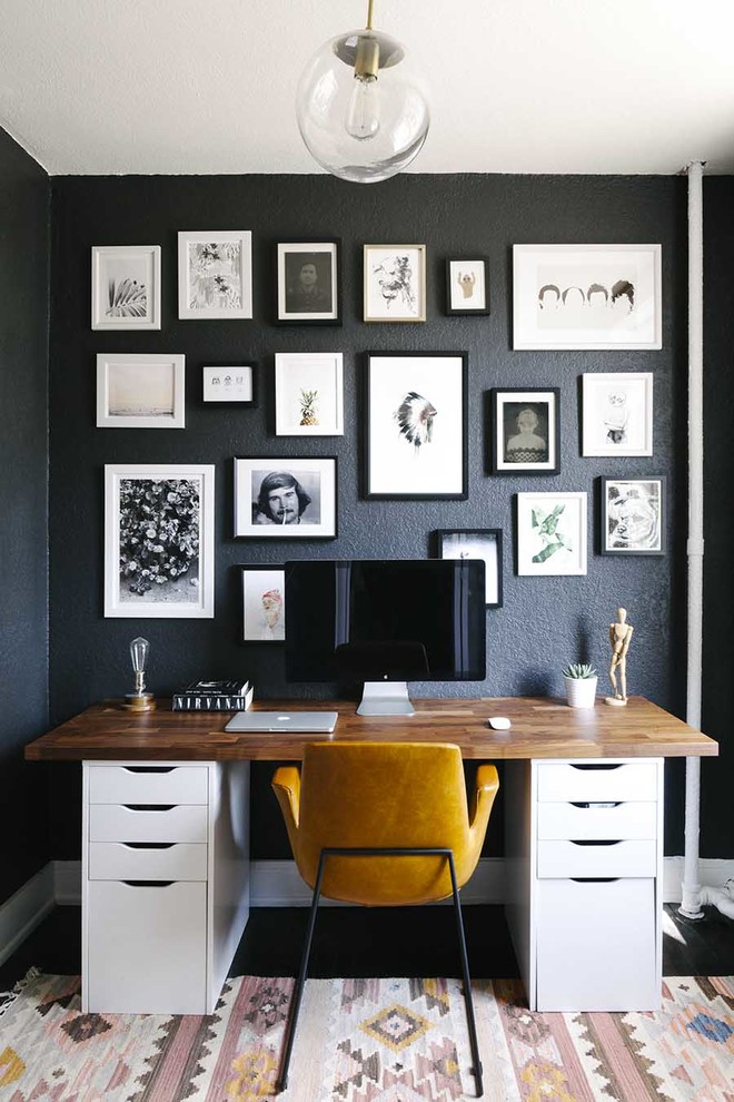 This is an example of a mid-sized scandinavian study room in Boston with black walls and a freestanding desk.