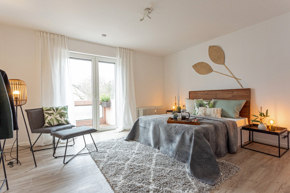 Idée de décoration pour une salle de séjour design de taille moyenne et fermée avec un mur blanc, sol en stratifié et un sol marron.
