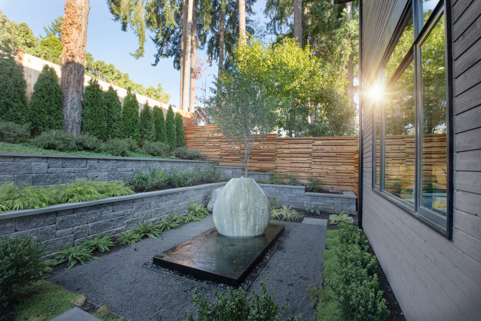 Mid-sized modern backyard full sun formal garden in Seattle with with rock feature and natural stone pavers.