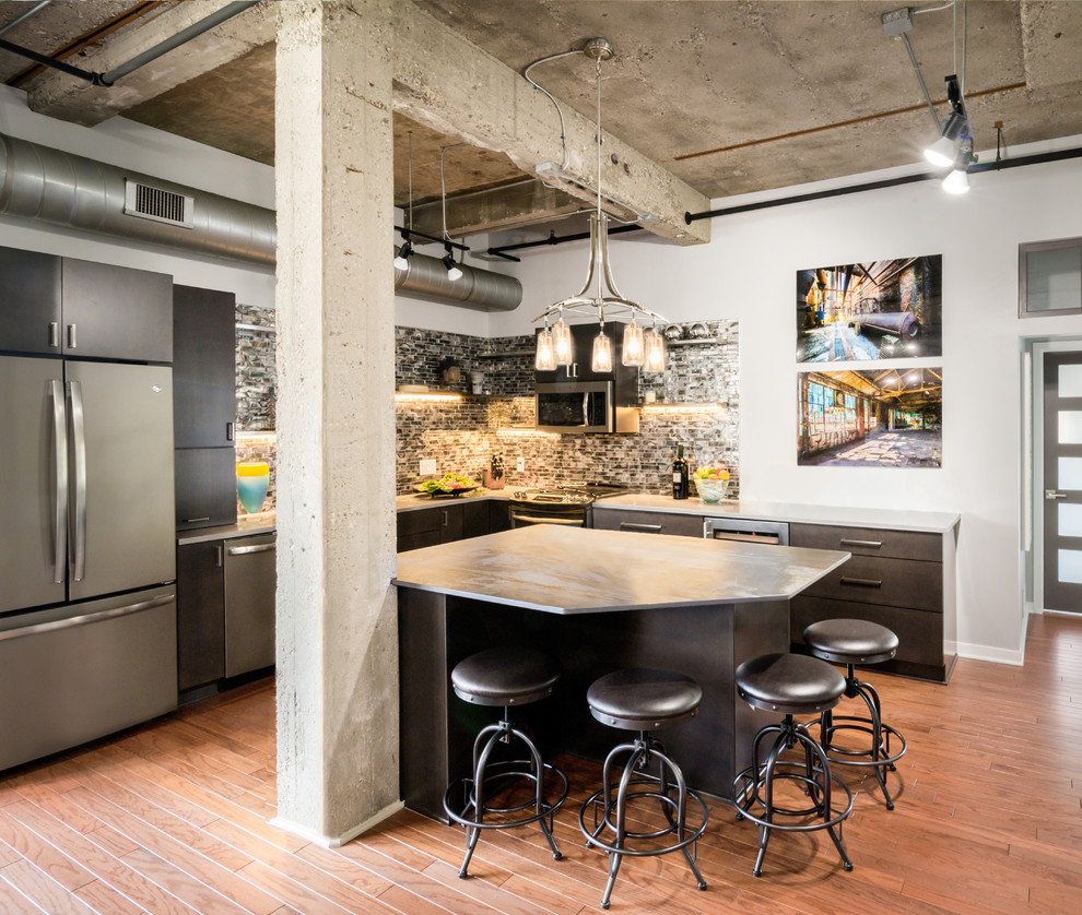 Photo of a mid-sized industrial l-shaped kitchen in Detroit with flat-panel cabinets, dark wood cabinets, multi-coloured splashback, stainless steel appliances, medium hardwood floors and with island.