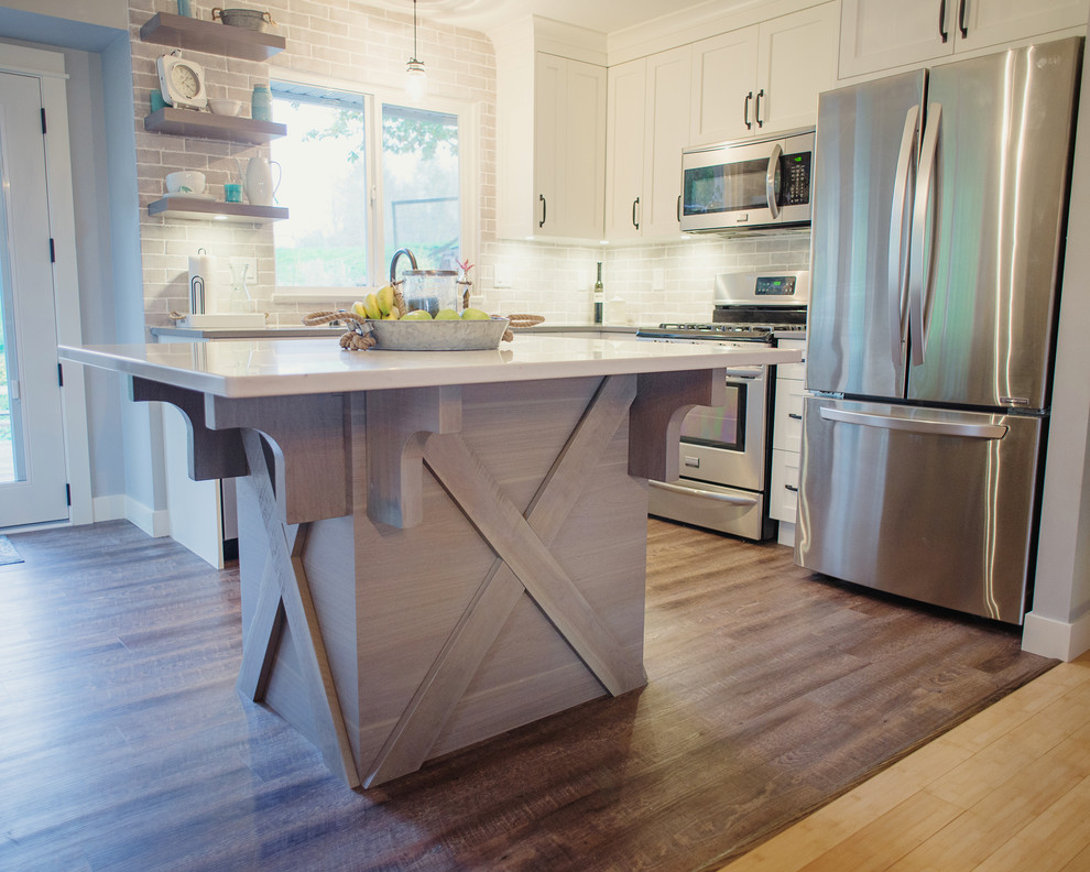 Inspiration for a mid-sized transitional l-shaped open concept kitchen remodel in Vancouver with an undermount sink, shaker cabinets, white cabinets, quartz countertops, gray backsplash, stainless steel appliances and an island