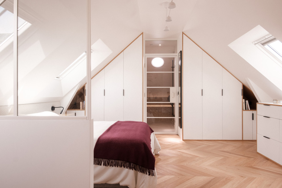 Idées déco pour une chambre parentale contemporaine de taille moyenne avec un mur blanc, parquet clair et dressing.
