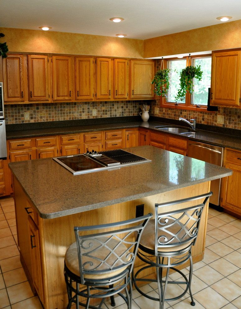 Inspiration for a mid-sized transitional l-shaped ceramic tile eat-in kitchen remodel in Cincinnati with an undermount sink, raised-panel cabinets, medium tone wood cabinets, quartz countertops, multicolored backsplash, stone tile backsplash, stainless steel appliances and an island