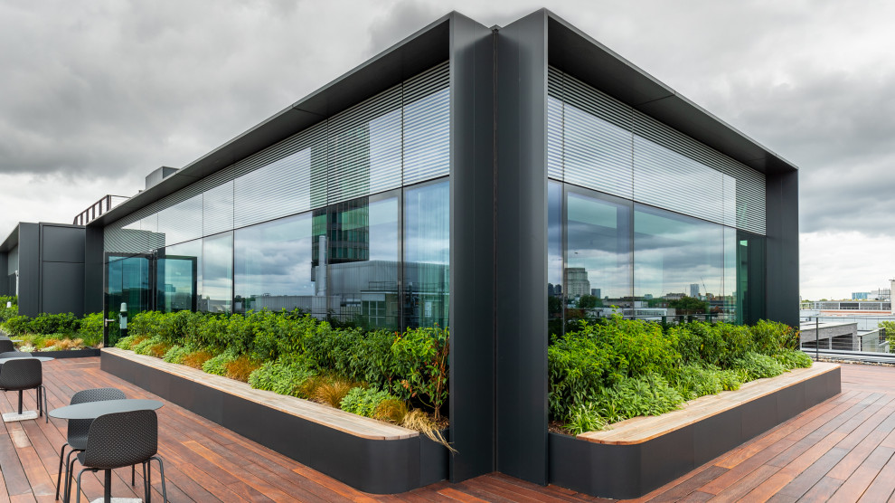 Foto di una grande terrazza contemporanea sul tetto e sul tetto con un giardino in vaso, nessuna copertura e parapetto in materiali misti