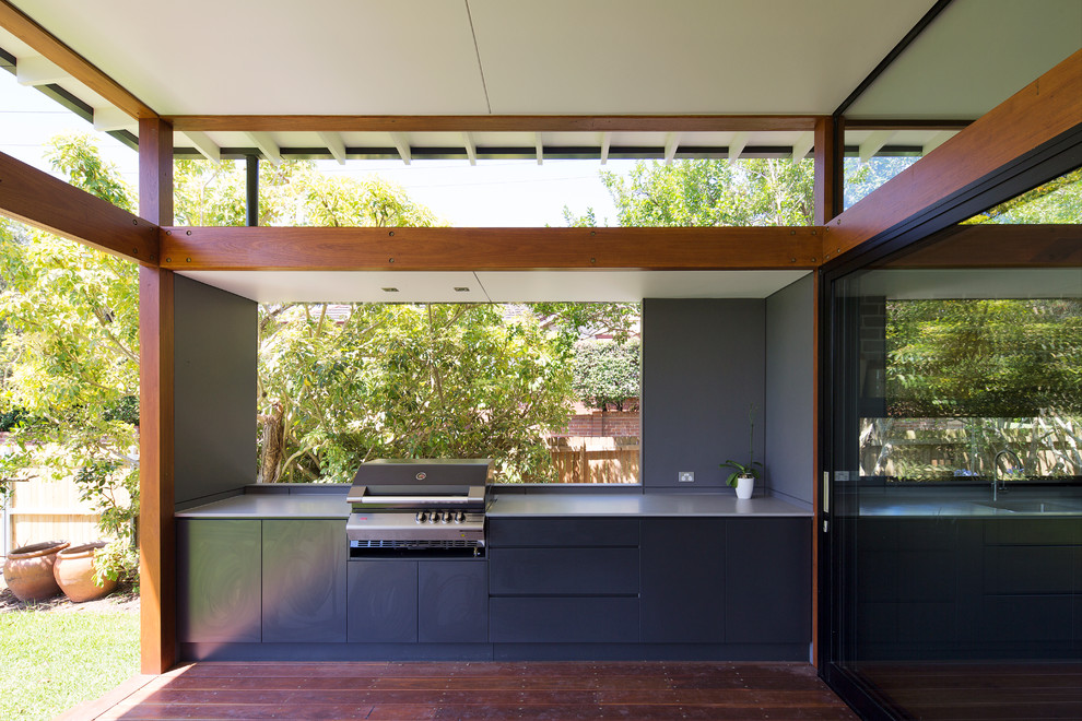 Design ideas for a large contemporary backyard deck in Sydney with an outdoor kitchen and a roof extension.