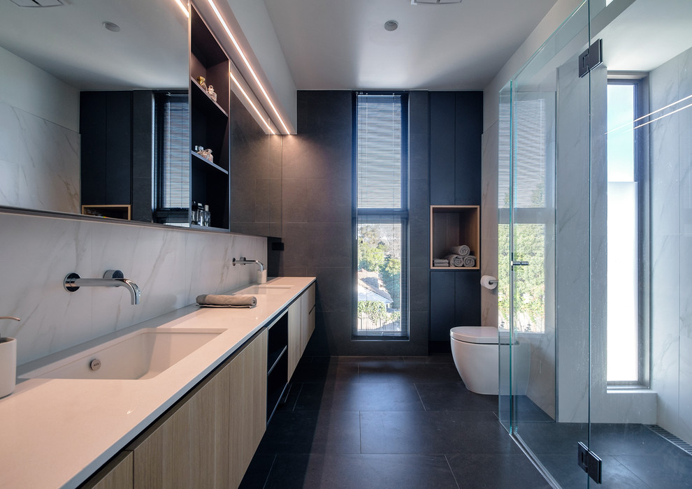 Inspiration for a mid-sized modern kids bathroom in Melbourne with flat-panel cabinets, light wood cabinets, an alcove shower, a one-piece toilet, white tile, porcelain tile, porcelain floors, a wall-mount sink, engineered quartz benchtops, grey floor, a hinged shower door, white benchtops and grey walls.