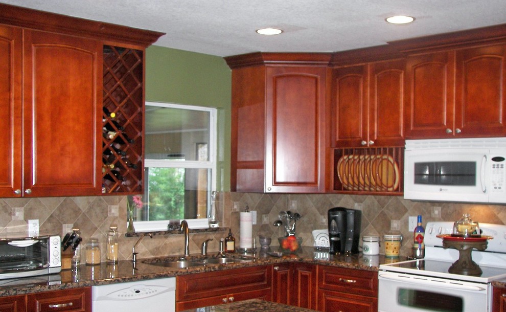 Inspiration for a mid-sized l-shaped kitchen remodel in Tampa with medium tone wood cabinets, marble countertops, beige backsplash and white appliances
