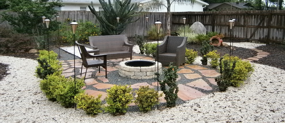 This is an example of a mid-sized asian front yard partial sun xeriscape for summer in Orlando with natural stone pavers and a fire feature.