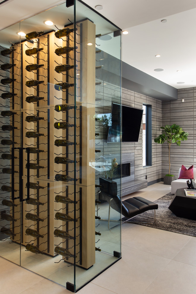Mid-sized modern wine cellar in Los Angeles with display racks, concrete floors and grey floor.