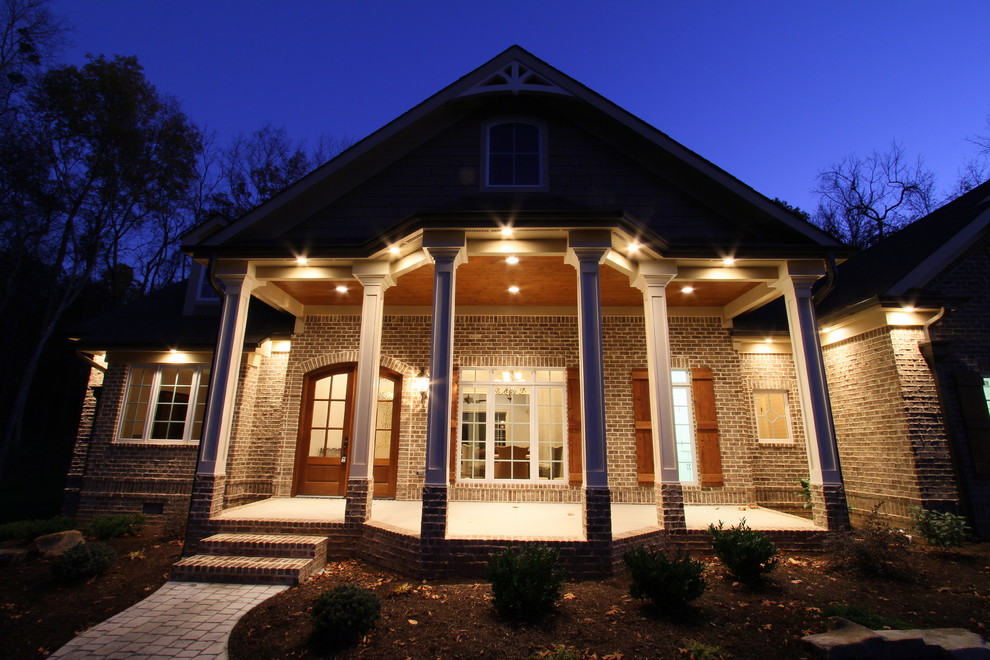 This is an example of a mid-sized traditional front yard verandah in Other with brick pavers and a roof extension.