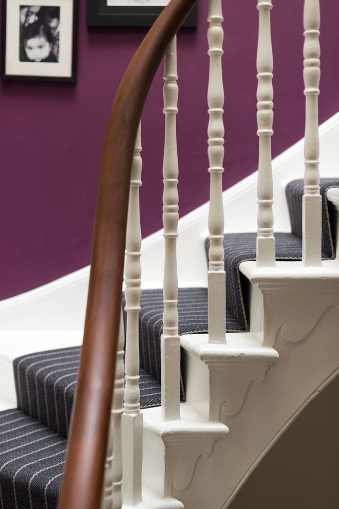Стильный дизайн: большая изогнутая лестница в современном стиле с ступенями с ковровым покрытием и ковровыми подступенками - последний тренд