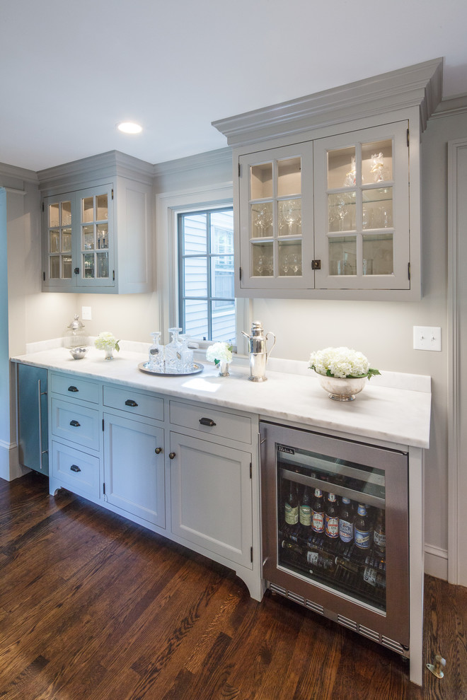 Example of a large transitional l-shaped dark wood floor kitchen design in Boston with a single-bowl sink, beaded inset cabinets, gray cabinets, marble countertops, gray backsplash, stone slab backsplash, paneled appliances and an island