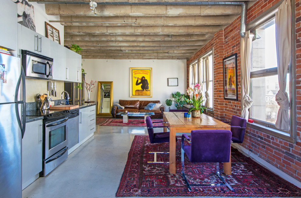 Photo of an industrial open plan dining in Los Angeles with concrete floors.