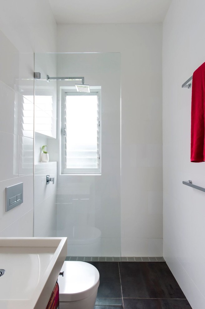 Inspiration for a small contemporary 3/4 bathroom in Sydney with furniture-like cabinets, white cabinets, an open shower, a wall-mount toilet, white tile, ceramic tile, white walls, porcelain floors, a wall-mount sink and solid surface benchtops.