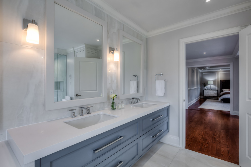 Mid-sized transitional master bathroom in Toronto with shaker cabinets, blue cabinets, a freestanding tub, a curbless shower, a one-piece toilet, beige tile, porcelain tile, white walls, porcelain floors, an undermount sink, quartzite benchtops, beige floor and a hinged shower door.