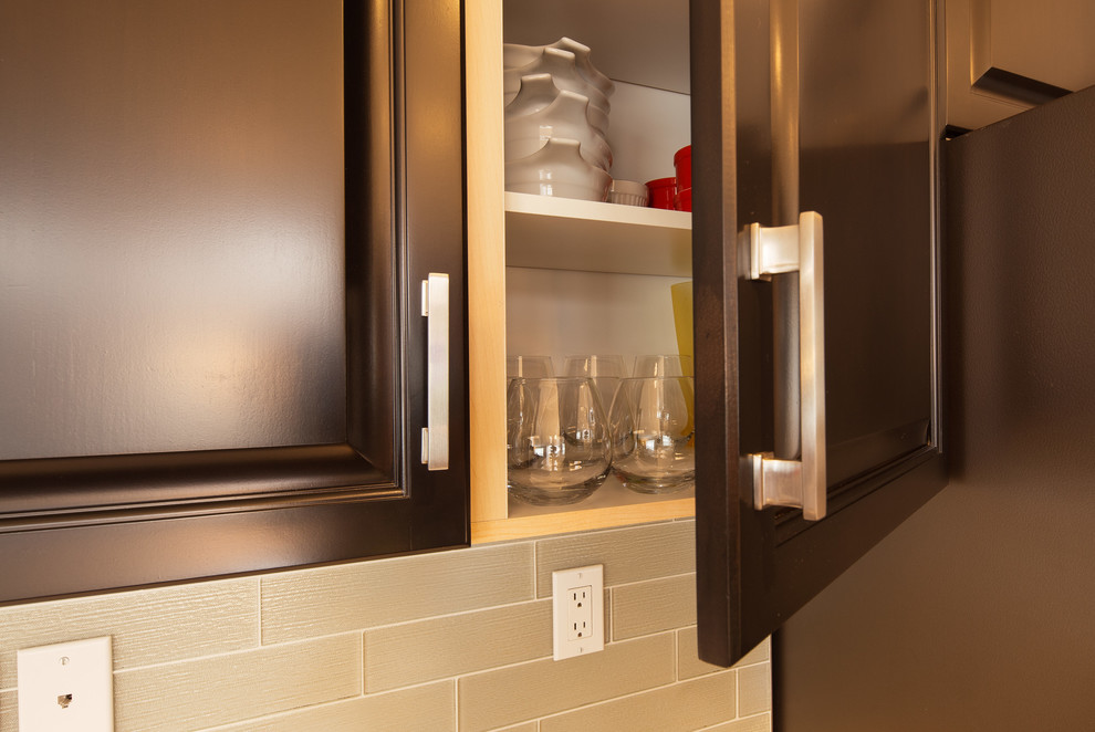 Large transitional u-shaped dark wood floor and brown floor eat-in kitchen photo in Calgary with a double-bowl sink, raised-panel cabinets, dark wood cabinets, quartz countertops, gray backsplash, ceramic backsplash, stainless steel appliances and an island