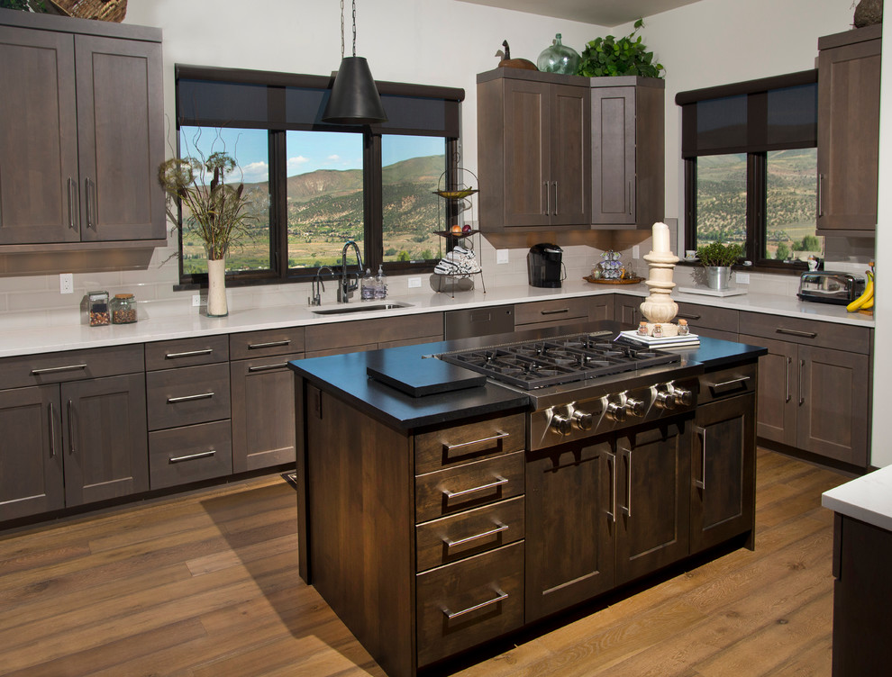 Large transitional u-shaped medium tone wood floor eat-in kitchen photo in Denver with an undermount sink, recessed-panel cabinets, gray cabinets, quartz countertops, white backsplash, ceramic backsplash, stainless steel appliances and two islands