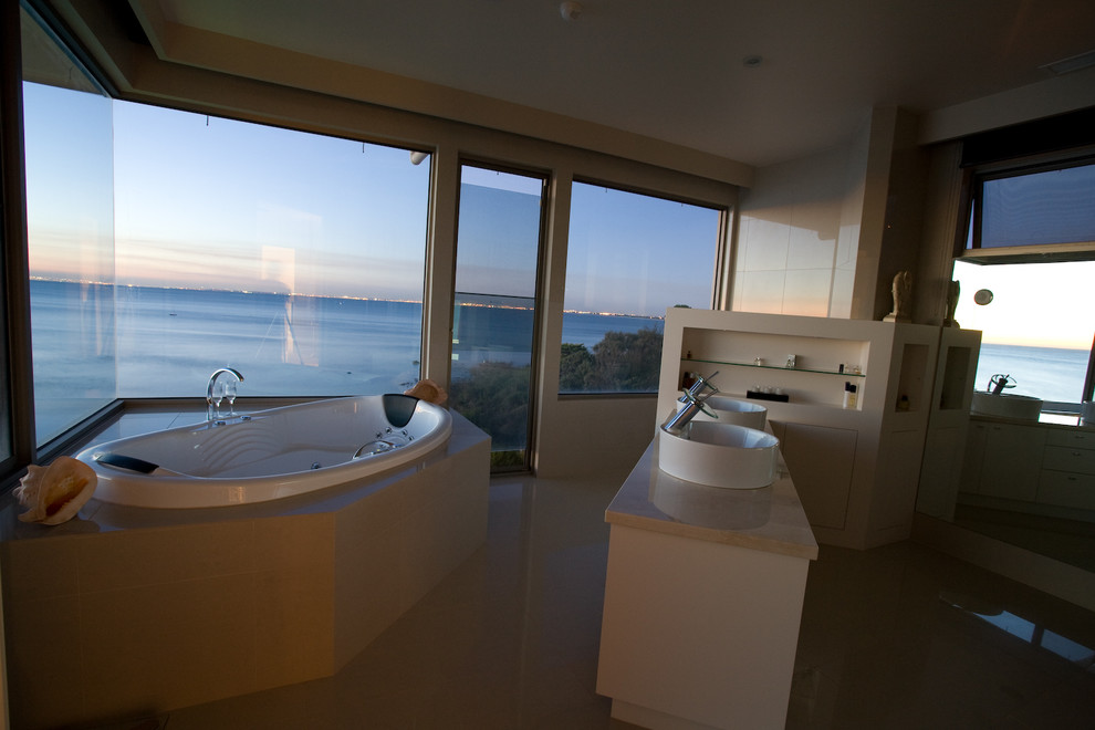 Mid-sized beach style master bathroom in Melbourne with a hot tub.