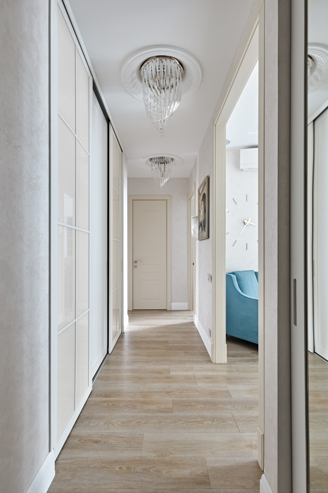 Стильный дизайн: узкий коридор среднего размера в стиле неоклассика (современная классика) с бежевыми стенами, полом из керамической плитки, белым полом, многоуровневым потолком и обоями на стенах - последний тренд