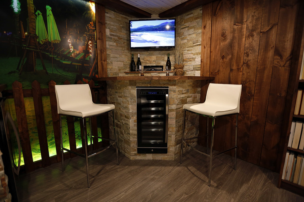 This is an example of a small beach style fully buried basement in Toronto with no fireplace and dark hardwood floors.