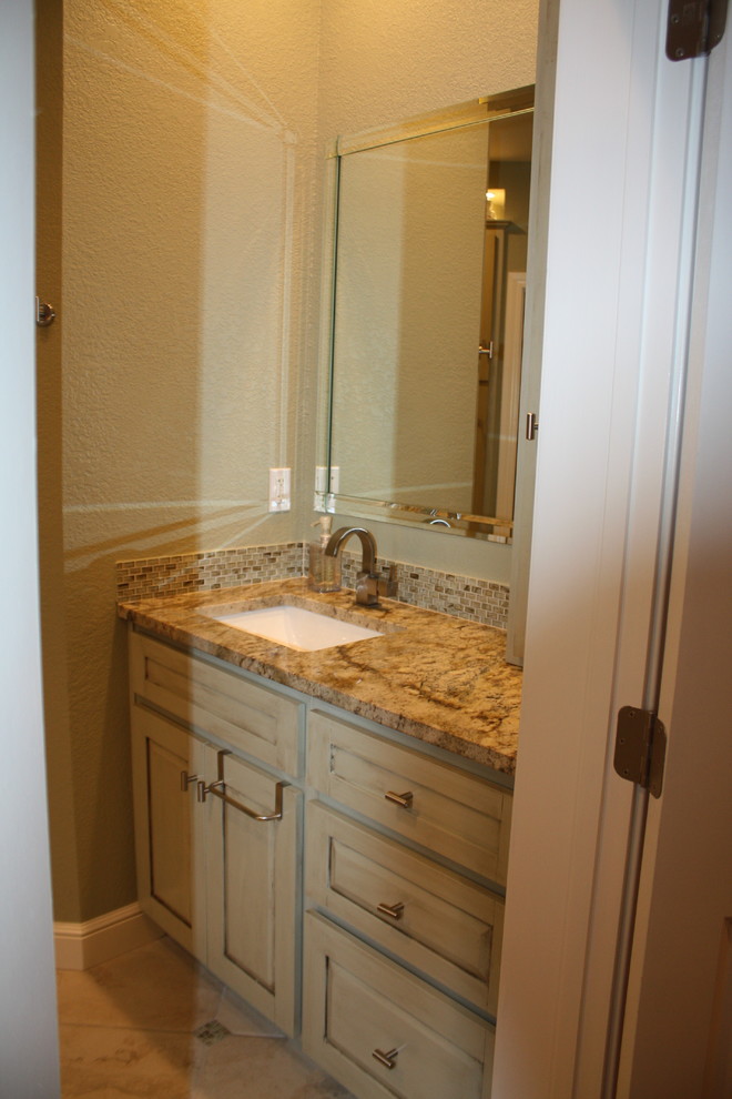 Example of a large transitional master multicolored tile and porcelain tile porcelain tile corner shower design with raised-panel cabinets, green cabinets, an undermount tub, green walls, an undermount sink and granite countertops